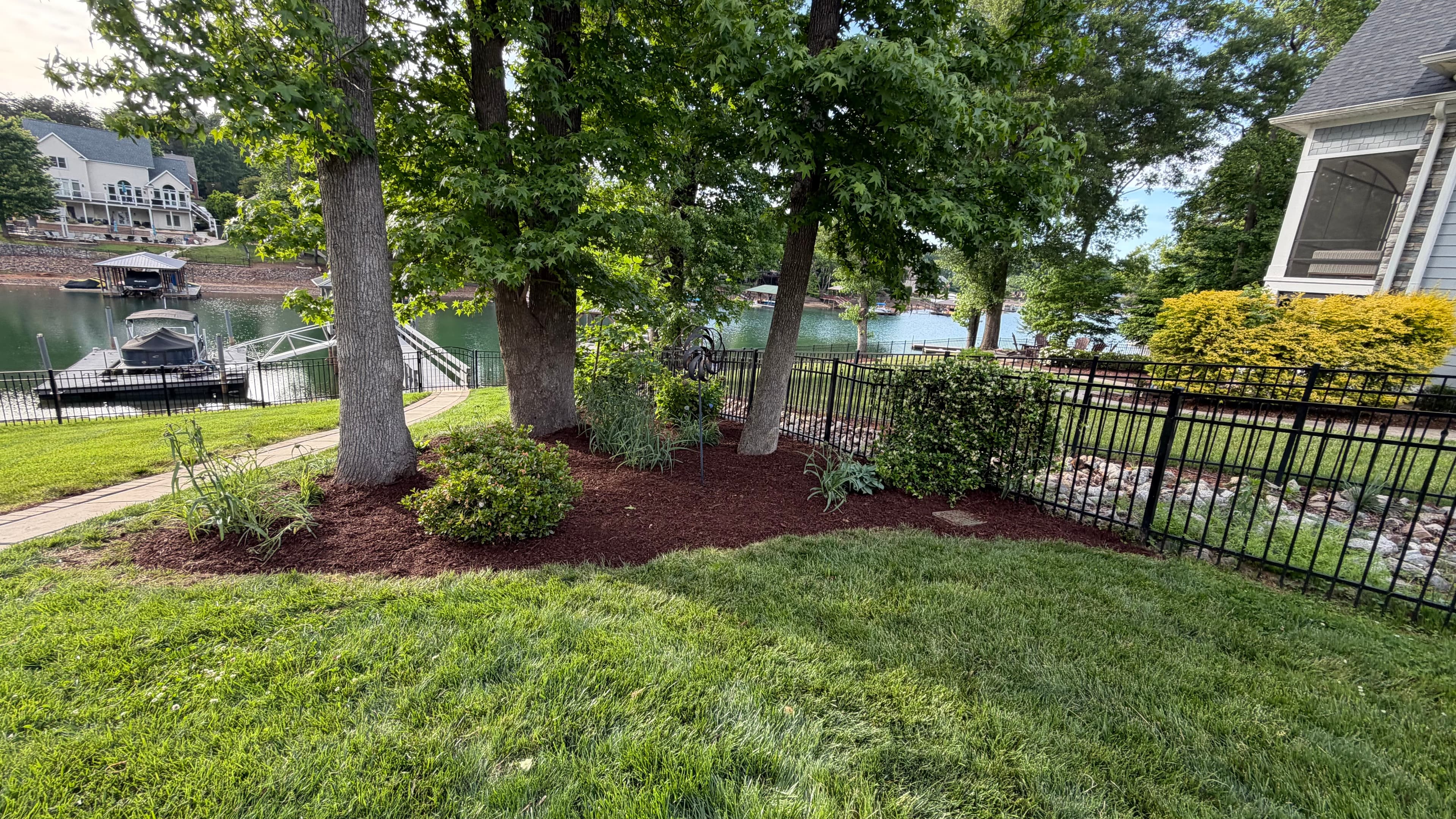 Lakefront Bed Cleanup & Mulch Install — After — cleared, edged, fresh mulch bed